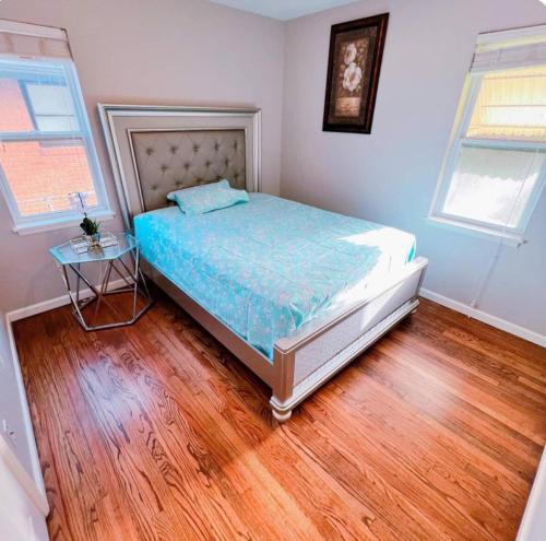 a bedroom with a bed and a wooden floor at Pet friendly 3 bedroom house in Oklahoma City
