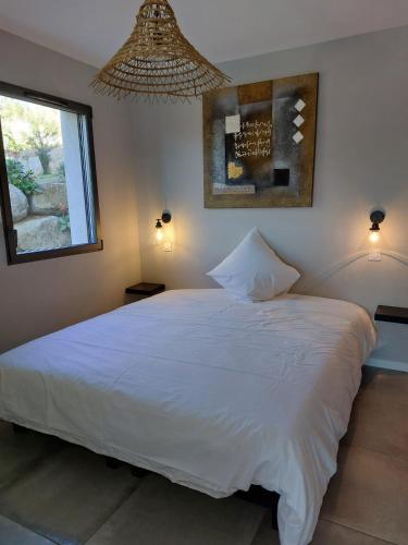 un grand lit blanc dans une chambre avec une fenêtre dans l'établissement Porto-Vecchio - Lecci Lodge, à Lecci
