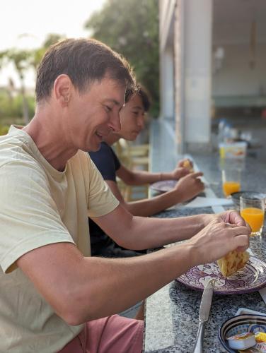 a man sitting at a table eating a sandwich at Dar Beynana in Sidi Bibi