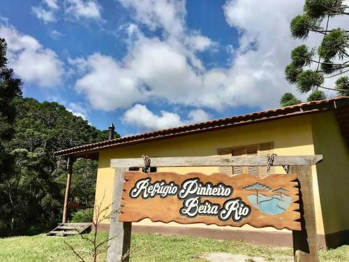 a sign for a restaurant in front of a building at Casa Araucária no Refugio Pinheiro Beira Rio in Sapucaí-Mirim