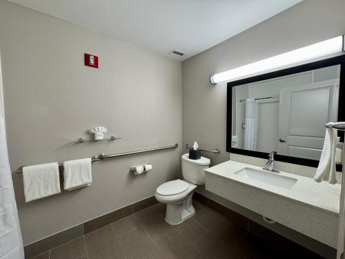 a bathroom with a toilet and a sink and a mirror at Garner Hotel Longview South by IHG in Longview