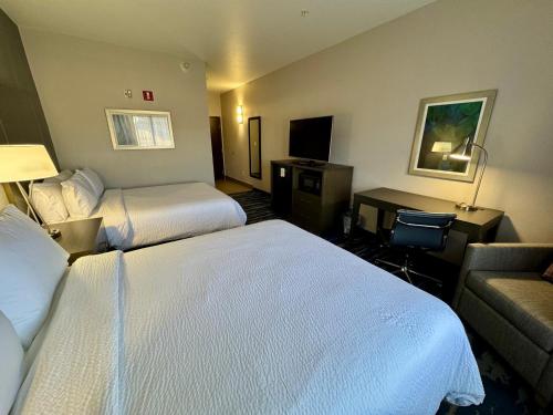 a hotel room with two beds and a couch at Garner Hotel Longview South by IHG in Longview