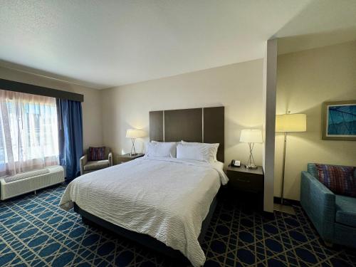 a hotel room with a large bed and a couch at Garner Hotel Longview South by IHG in Longview