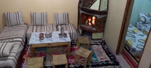 a living room with a table and a fireplace at Gite Soleil in Tacheddirt
