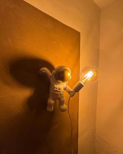 a toy astronaut is plugged into a light on a wall at Lehmhäuschen mit Sauna in Tangermünde