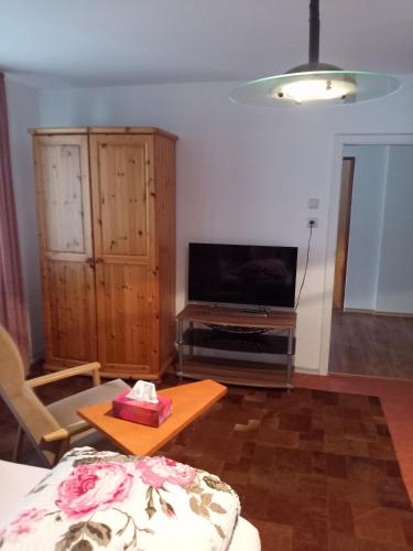 a living room with a television and a table at Haus Mühlgraben in Ramsau