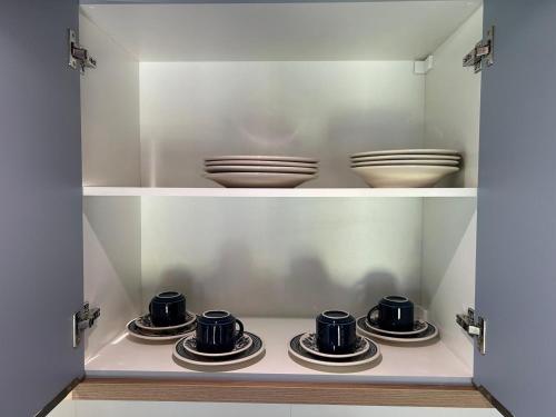 a cupboard with plates and bowls on top at Pousada Chalé Flor de Hibisco 1 in Penha