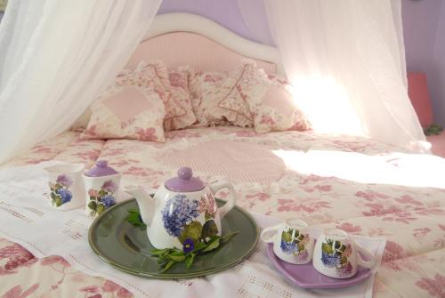 a tray with a tea set on a bed at La Dimora le Fumarole Rooms in Ercolano