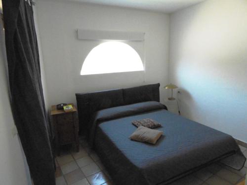 um pequeno quarto com uma cama e uma janela em Trilocale I Meridiani Le Maree 4T em Cannigione