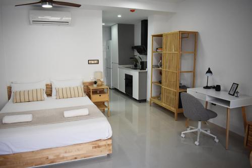 a bedroom with a bed and a desk and a deskablish at Ecoloft Estudios in Cartagena