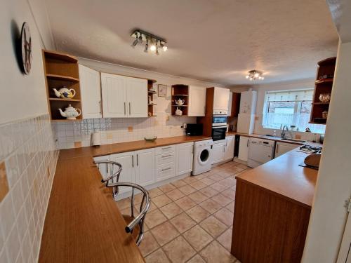 a kitchen with white cabinets and a counter top at Spacious Four Bedroom House, 3 min walk to beach in Paignton