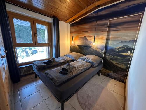 a bed in a room with a painting on the wall at La Baita Residence 3.0 in Folgarida
