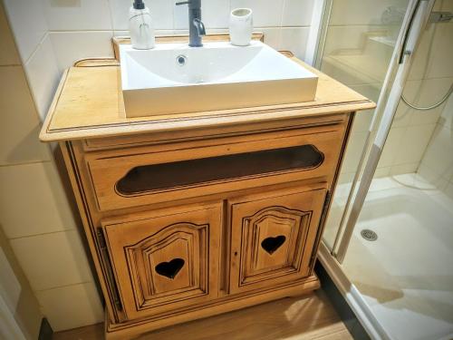 a bathroom with a sink and a wooden vanity at Le Belvédère : chambres et table d'hôtes in Montmélian