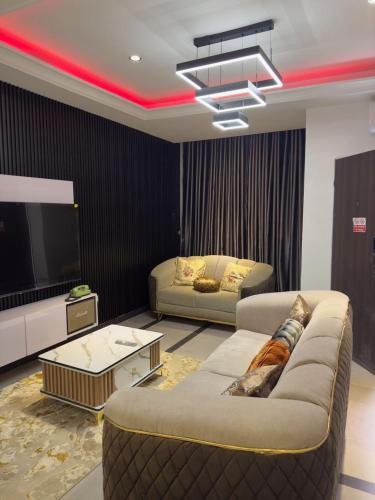 Una sala de estar con un sofá y un televisor. en Molarans Place, en Abuja
