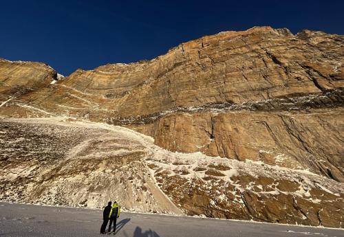 two people are standing in front of a mountain at Ice Hut on the Sea Ice in Uummannaq
