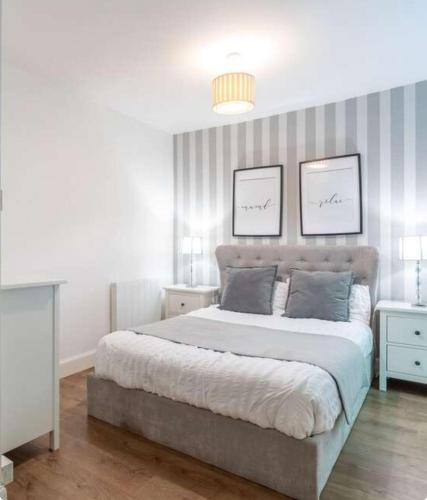 a bedroom with a large bed with two pictures on the wall at The Gardners apartment in City centre with parking in Edinburgh