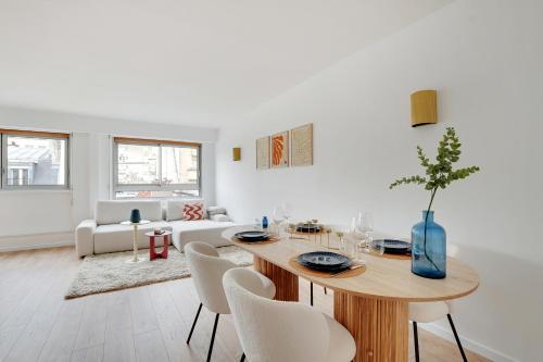 un salon blanc avec une table et des chaises dans l'établissement Eiffel Tower - Passy, Paris, à Paris