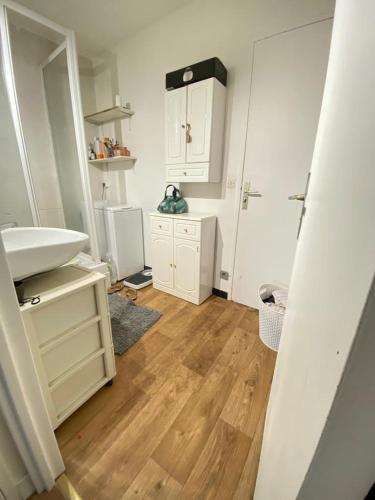 La salle de bains est pourvue d'un lavabo blanc et de parquet. dans l'établissement Apartment 2 Chambres avec 2 Balcons, Évry-Courcouronnes