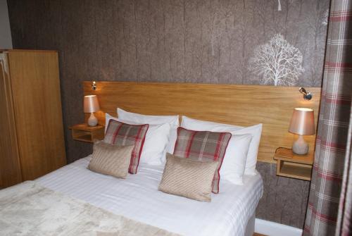 a bedroom with a white bed with two pillows at The Coppice - including off-site health club in Windermere