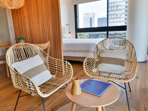 a room with two chairs and a table and a bed at Modern & Bright Studio in Asuncion