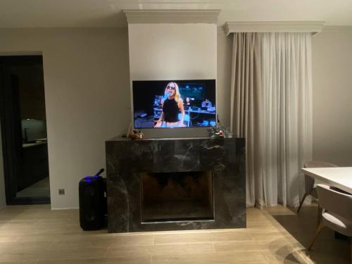 a living room with a fireplace with a flat screen tv at L&vHOUSE in Dilijan