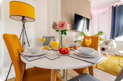 a dining room table with chairs and a white table with drinks at 1 bed Flat ''Beta'' in Dewsbury road, Leeds in Hunslet