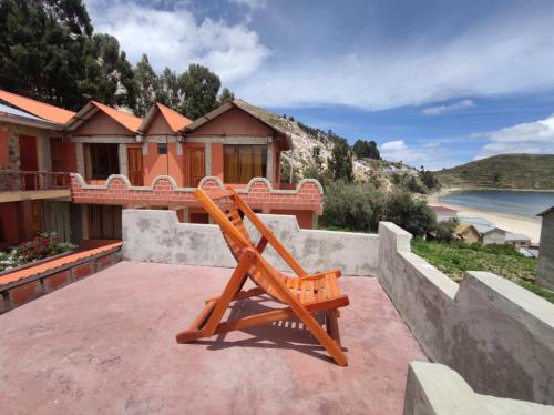 a wooden chair sitting on top of a patio at Hostal Margarita in Comunidad Challapampa