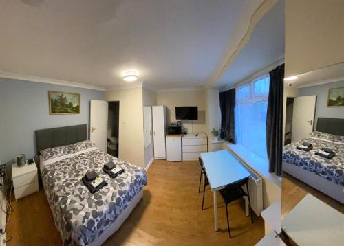a room with two beds and a table in it at Kensal Lodge Guest House in London