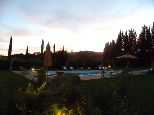 a sunset over a swimming pool in a garden at Ghiaccio Bosco in Capalbio