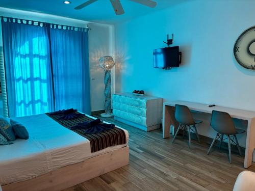 a bedroom with a bed and a desk with chairs at Coco Rio Hotel - Mamitas Beach Area in Playa del Carmen