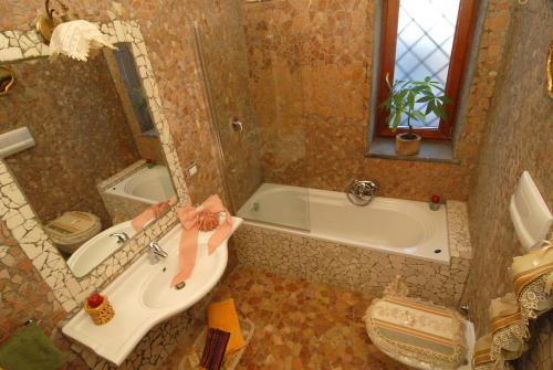 a bathroom with a tub and a sink and a bath tub at La Dimora le Fumarole Rooms in Ercolano