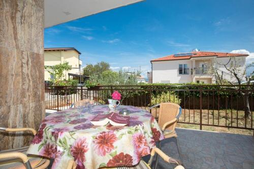 a table with a vase of flowers on a patio at Apartments Kate in Malinska