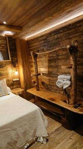 a log cabin bedroom with a bed and wooden walls at Casa Antón O Cebreiro in O Cebreiro