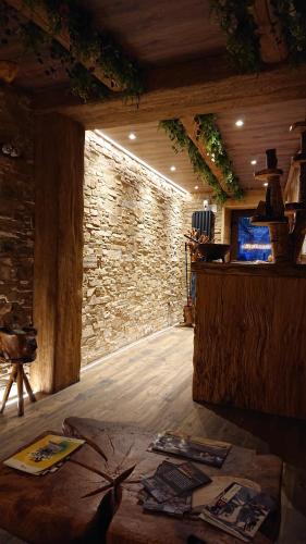 a room with a stone wall and a wooden floor at Casa Antón O Cebreiro in O Cebreiro