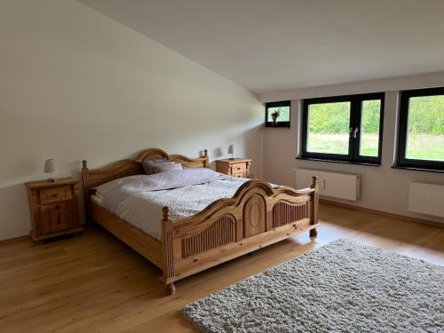 una camera con un grande letto in legno e un tappeto di Haus am See - Ferienwohnung mit Panoramablick ad Angermünde