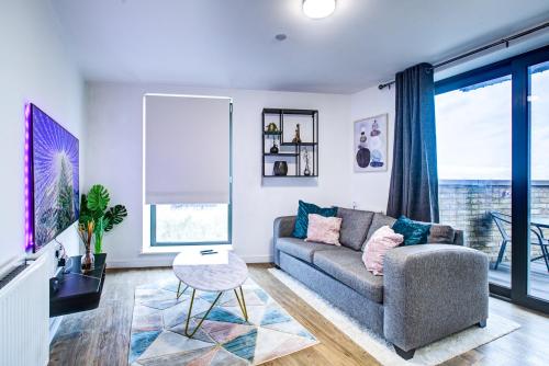 a living room with a couch and a table at Luxee Apartment by Excel in London