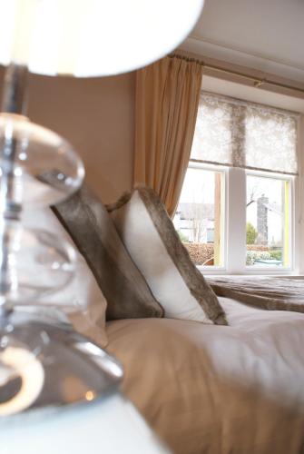 a bed with white pillows and a window at The Coppice - including off-site health club in Windermere