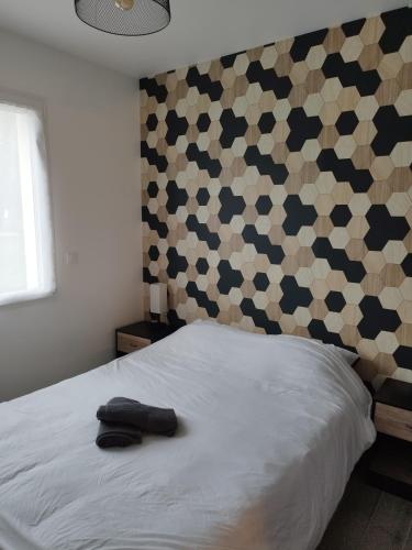 - une chambre avec un lit blanc et un mur à motifs dans l'établissement Domaine de Veauce proche de Bourges, à Saint-Doulchard