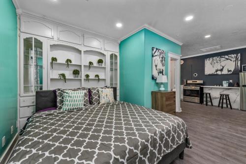 a bedroom with a bed and a blue wall at Comfy Studio with King Bed & Full Kitchen - Near Attractions in Houston