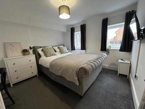 a bedroom with a large bed and a window at The Old Band Accommodation 1 kingsize bed and 1 Sofa Bed available in Higham Ferrers