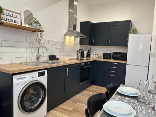 a kitchen with a washer and a sink and a dishwasher at The Old Band Accommodation 1 kingsize bed and 1 Sofa Bed available in Higham Ferrers