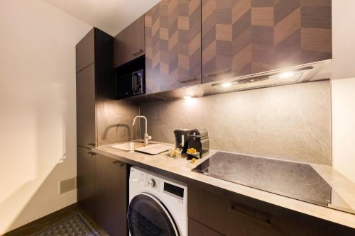 une cuisine avec une machine à laver et un évier dans l'établissement Parking Gratuit - Montmartre Charme & Patio Privé - Sacré-Cœur Metro Anvers, à Paris
