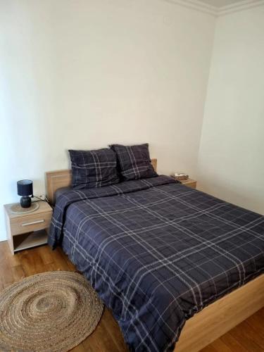 - une chambre dotée d'un lit avec une couverture bleue dans l'établissement F3 lumineux et rénové, Centre ville, à Vitry-le-François