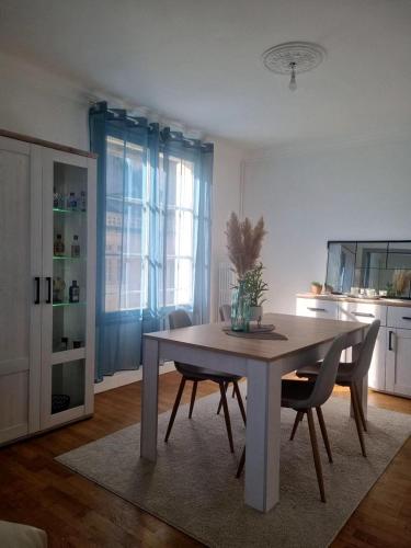 - une table à manger et des chaises dans la cuisine dans l'établissement F3 lumineux et rénové, Centre ville, à Vitry-le-François