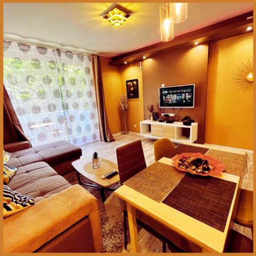 un salon avec un canapé et une table dans l'établissement Sweet & Home - Centre-ville & Proche Circuit des 24H - Climatisé - Parking - by Le Mans City, au Mans