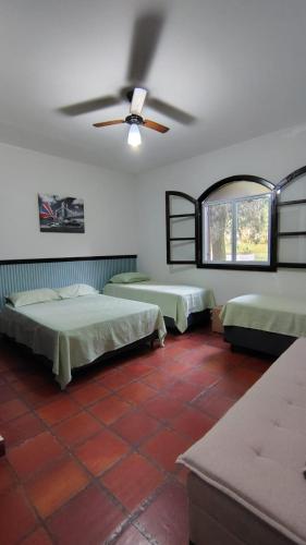 a bedroom with two beds and a ceiling fan at Chácara Monteiro - Próximo ao Thermas Water Park in São Pedro