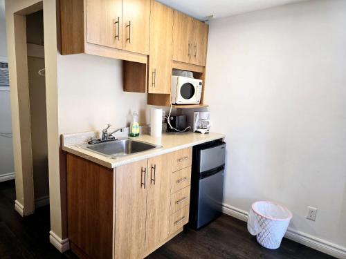 a small kitchen with a sink and a microwave at Motel LA RÉFÉRENCE in Trois-Rivières