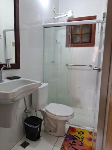 a bathroom with a toilet and a sink and a shower at Encantos do mar in Arraial do Cabo