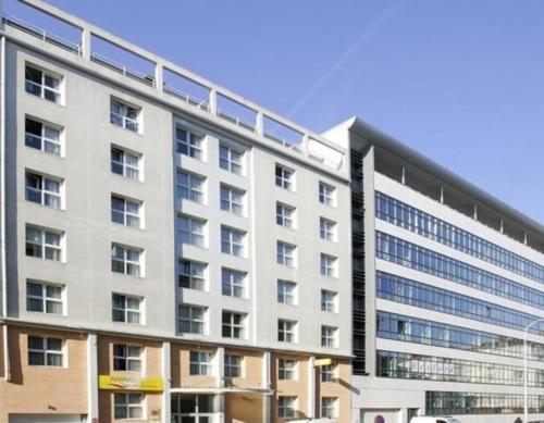 duży biały budynek z wieloma oknami w obiekcie Chatillon Citea Access dayuse Room - Work and Day Rest Timeshare --15 minutes Paris Montparnasse -- - Formule Temps Partagé w mieście Châtillon