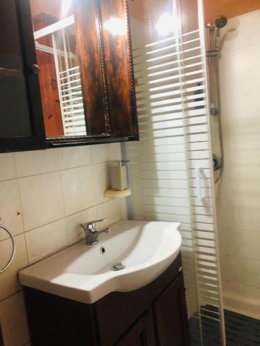 a bathroom with a sink and a mirror and a shower at Appartamento con cucina a Taormina centro con vista mare e su l'etna casa Muscolino in Taormina